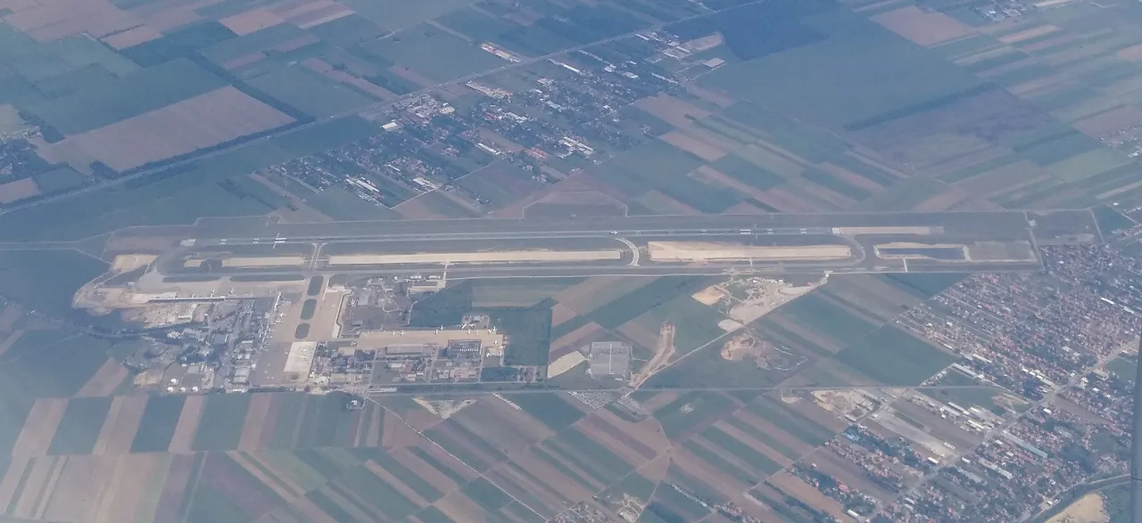 Aerial view of Belgrade Nikola Tesla Airport with its terminal, apron and runway laid out below