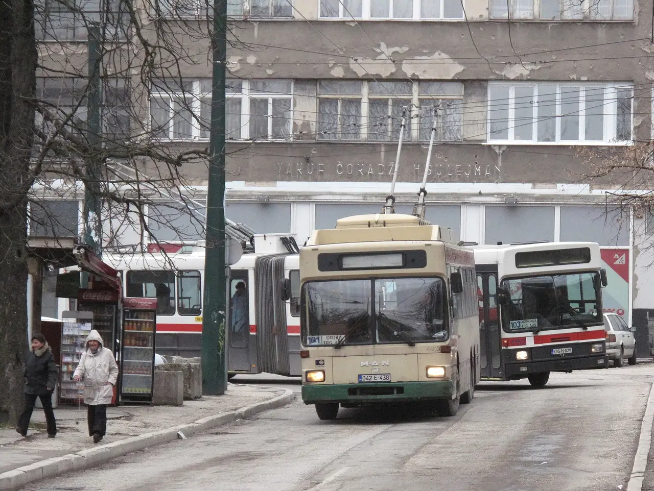A trolleybus on a Sarajevo street with the valley hills rising behind it