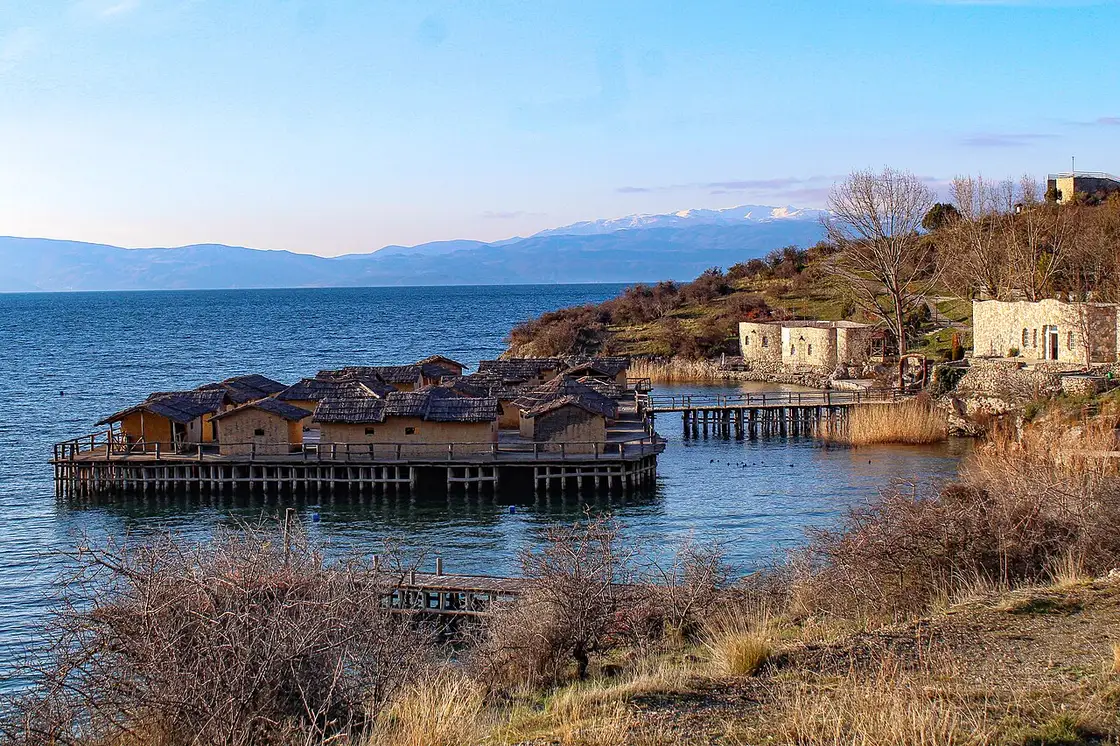 Winter view of the whole Bay of Bones complex from the shore, with Lake Ohrid and snow-dusted mountains behind