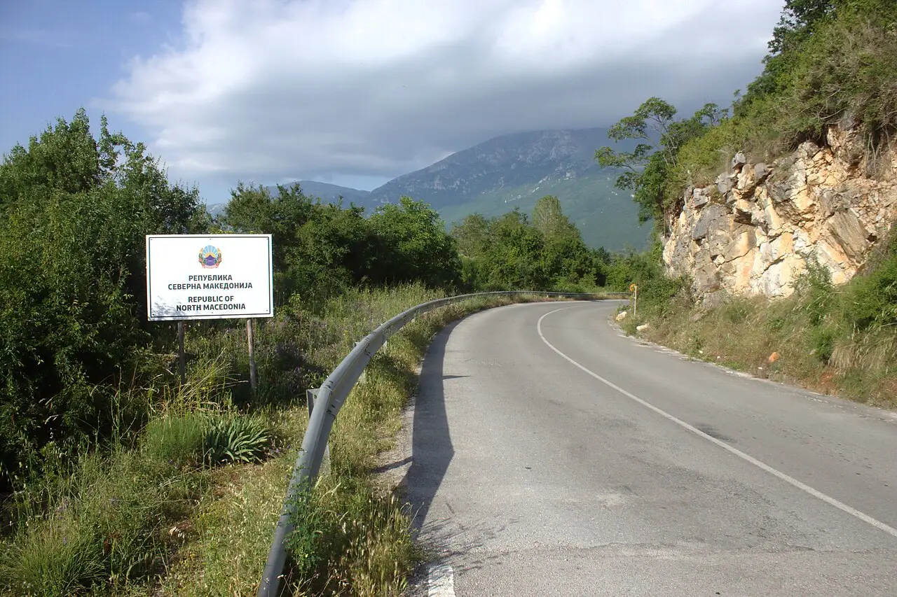 A Republic of North Macedonia border sign beside a mountain road near Sveti Naum