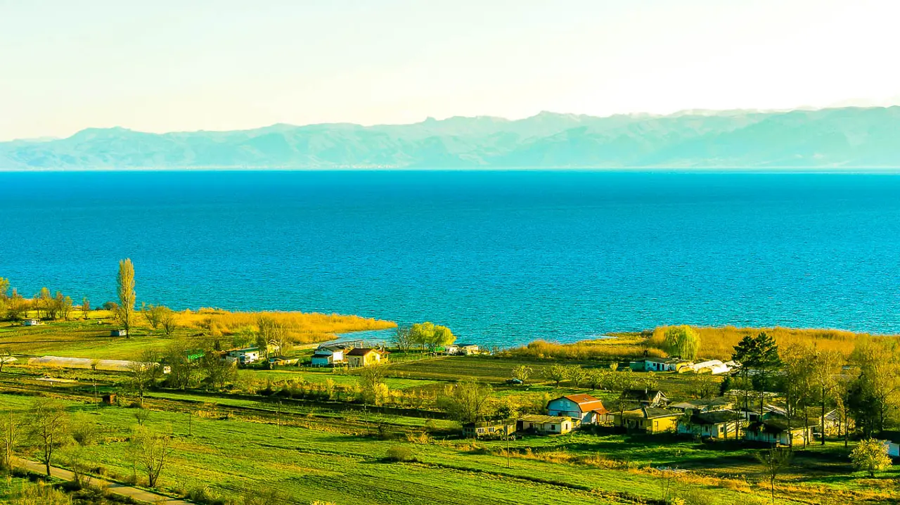 A summer day on the shore of Lake Ohrid with clear blue water and green hills