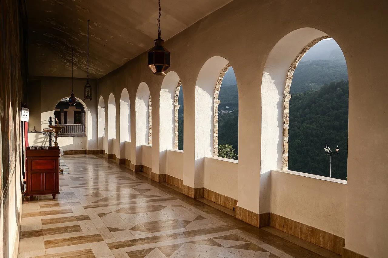A long arcaded gallery inside the monastery with arched windows looking out over the wooded gorge
