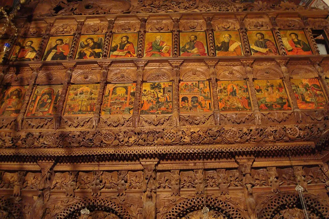 Rows of painted icons set into the carved walnut frame of the Bigorski iconostasis