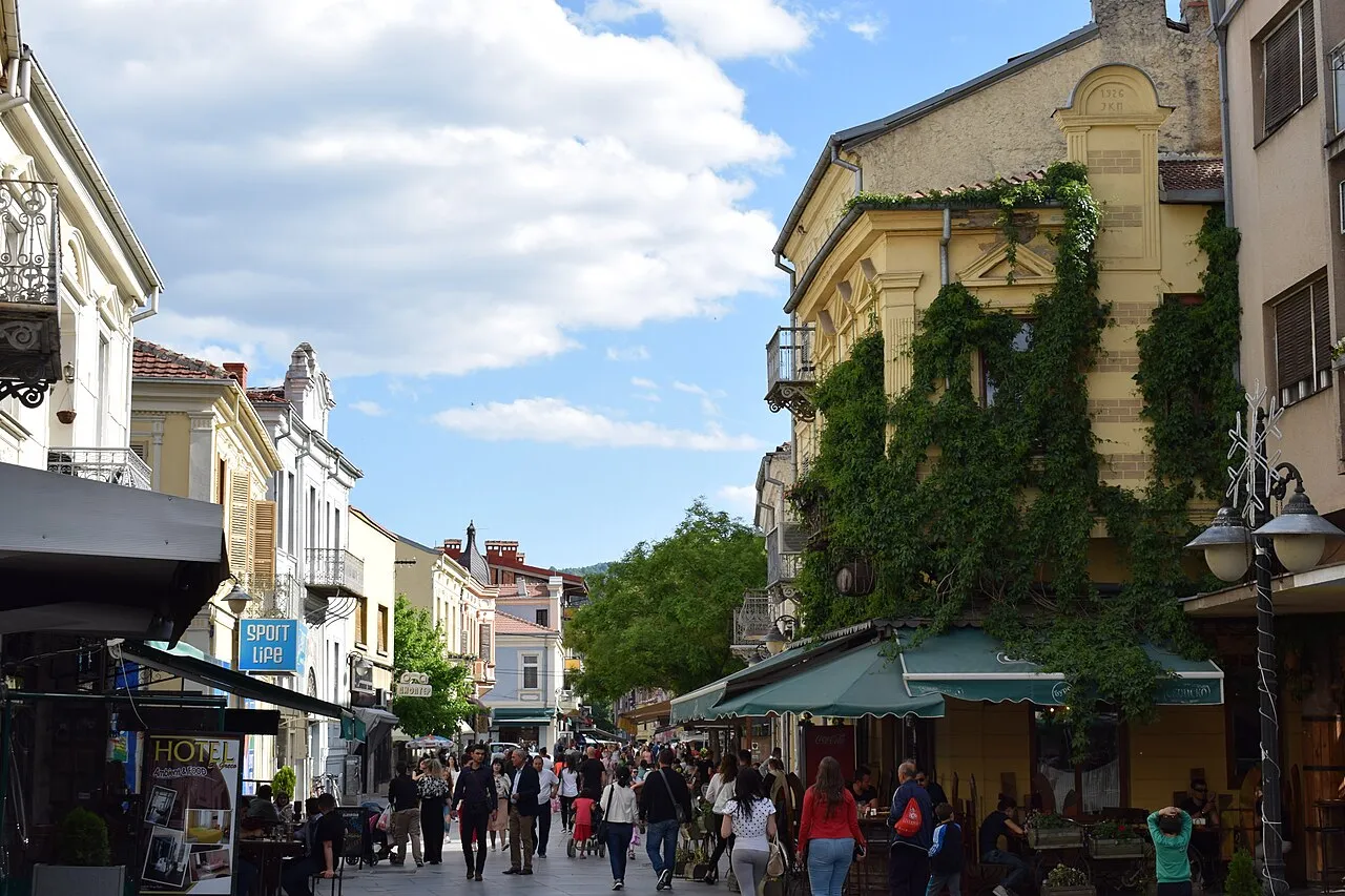 A pedestrian street in central Bitola lined with nineteenth-century facades, cafes and pedestrians on a sunny afternoon