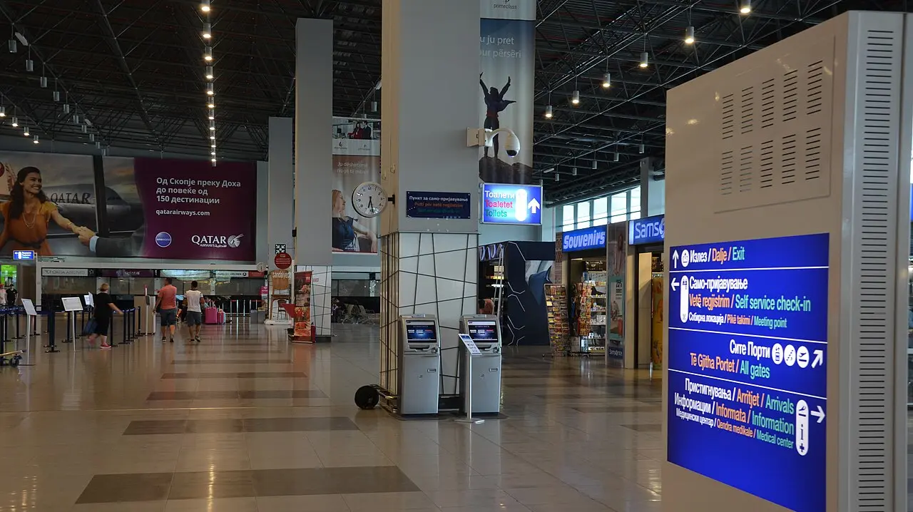 The concourse inside Skopje airport terminal with signage in Macedonian, Albanian and English