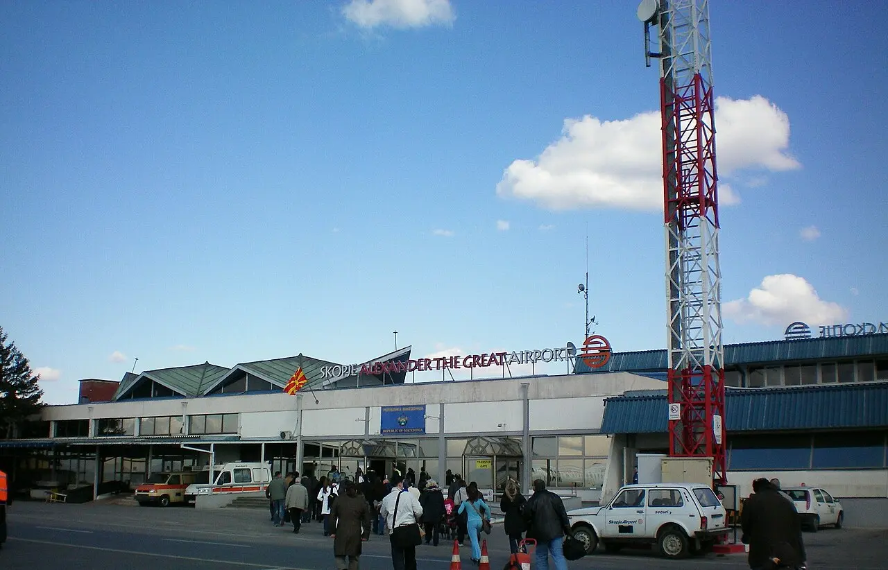 The front of Skopje airport terminal with cars, taxis and arriving passengers outside the entrance