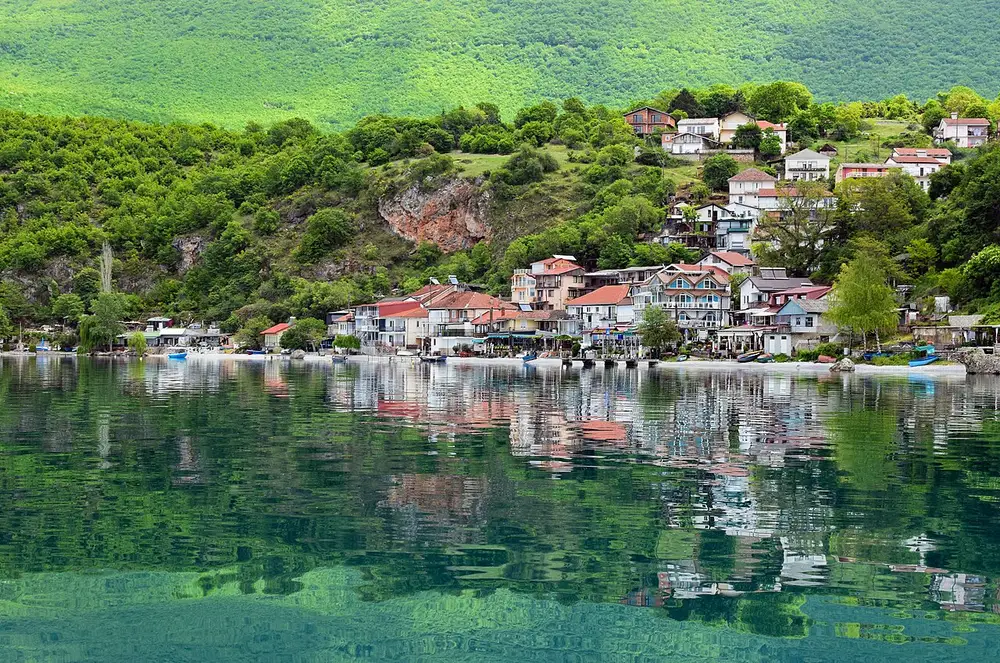 Lake Ohrid shoreline with mountains across the water under a bright sky