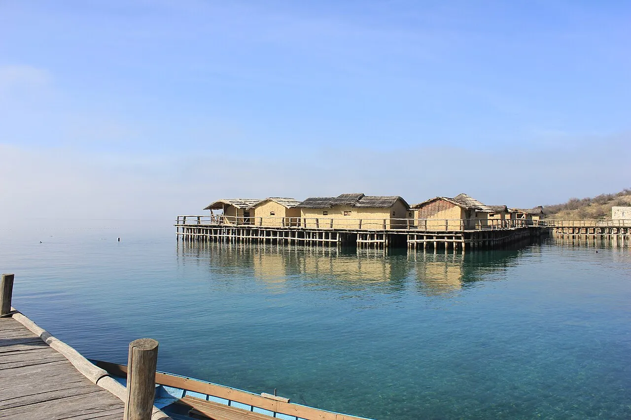 Wooden boats moored on the clear blue water of Lake Ohrid with the town behind