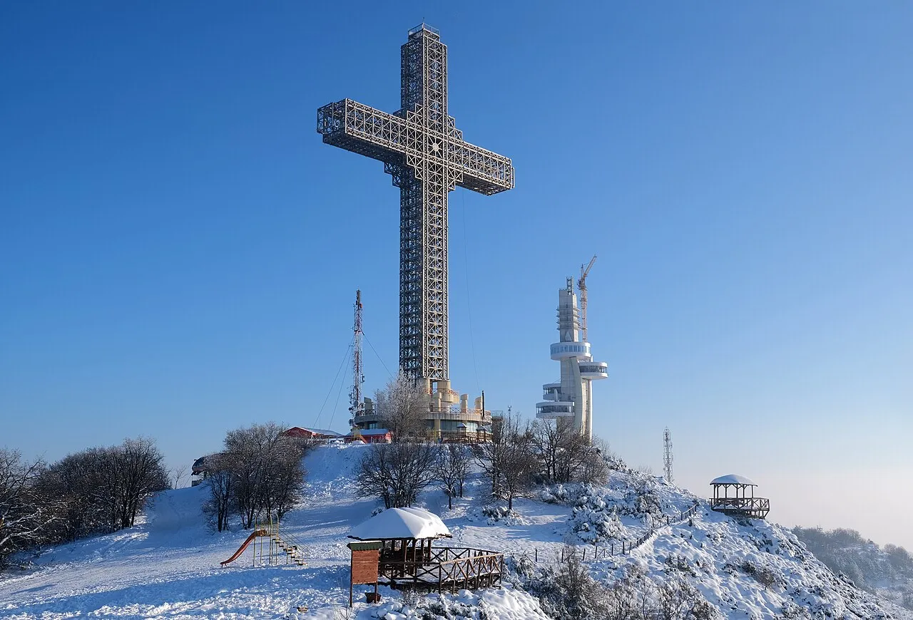 The lattice-steel Millennium Cross on the snowy summit of Mount Vodno above Skopje