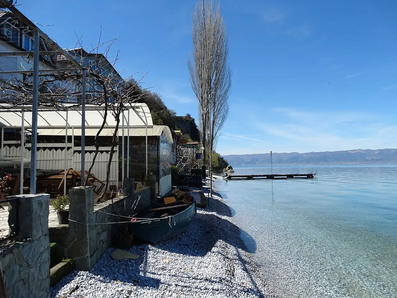 Wooden boats moored on the clear water of Lake Ohrid near the village of Trpejca