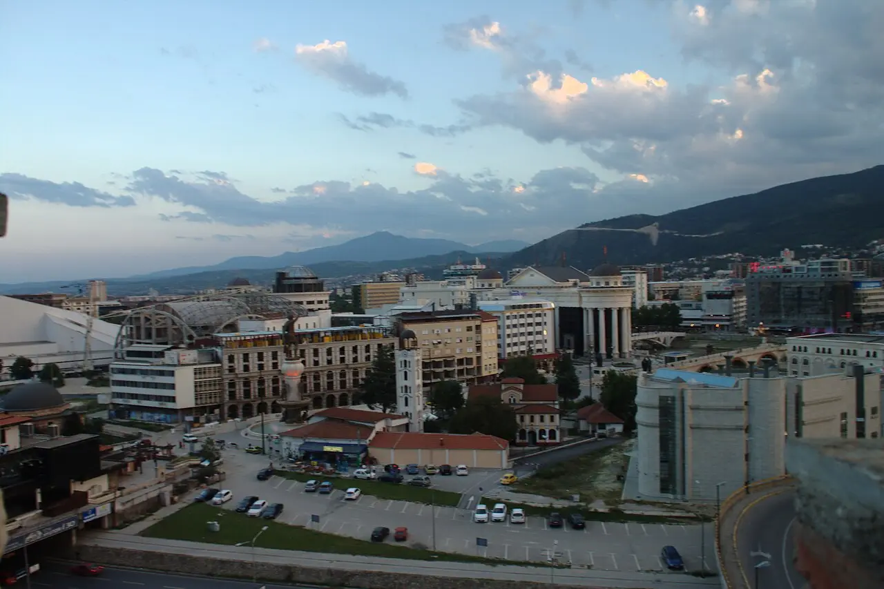 A wide dusk view over central Skopje from Kale Fortress, with Macedonia Square and the surrounding hills