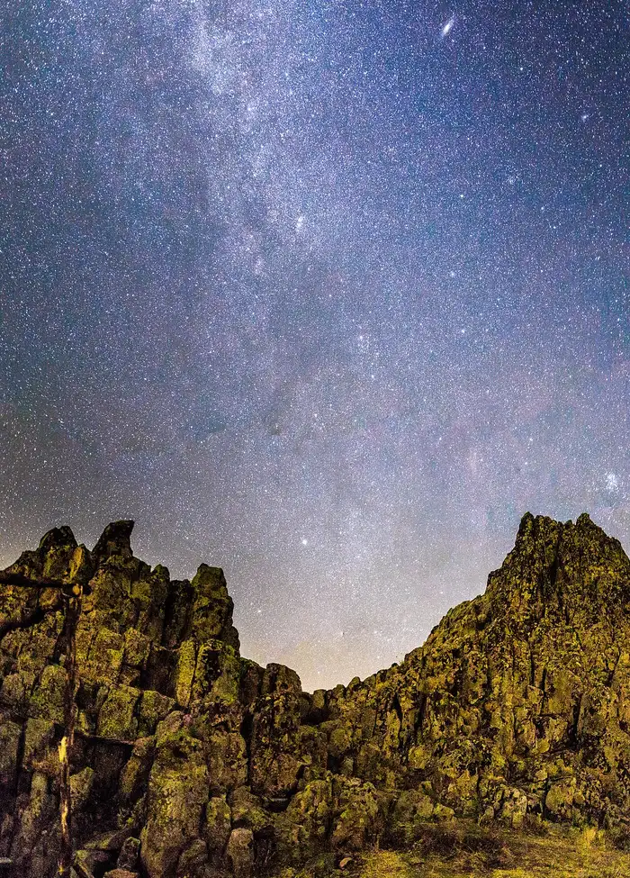 The Milky Way arching over the dark rock formations of Kokino at night