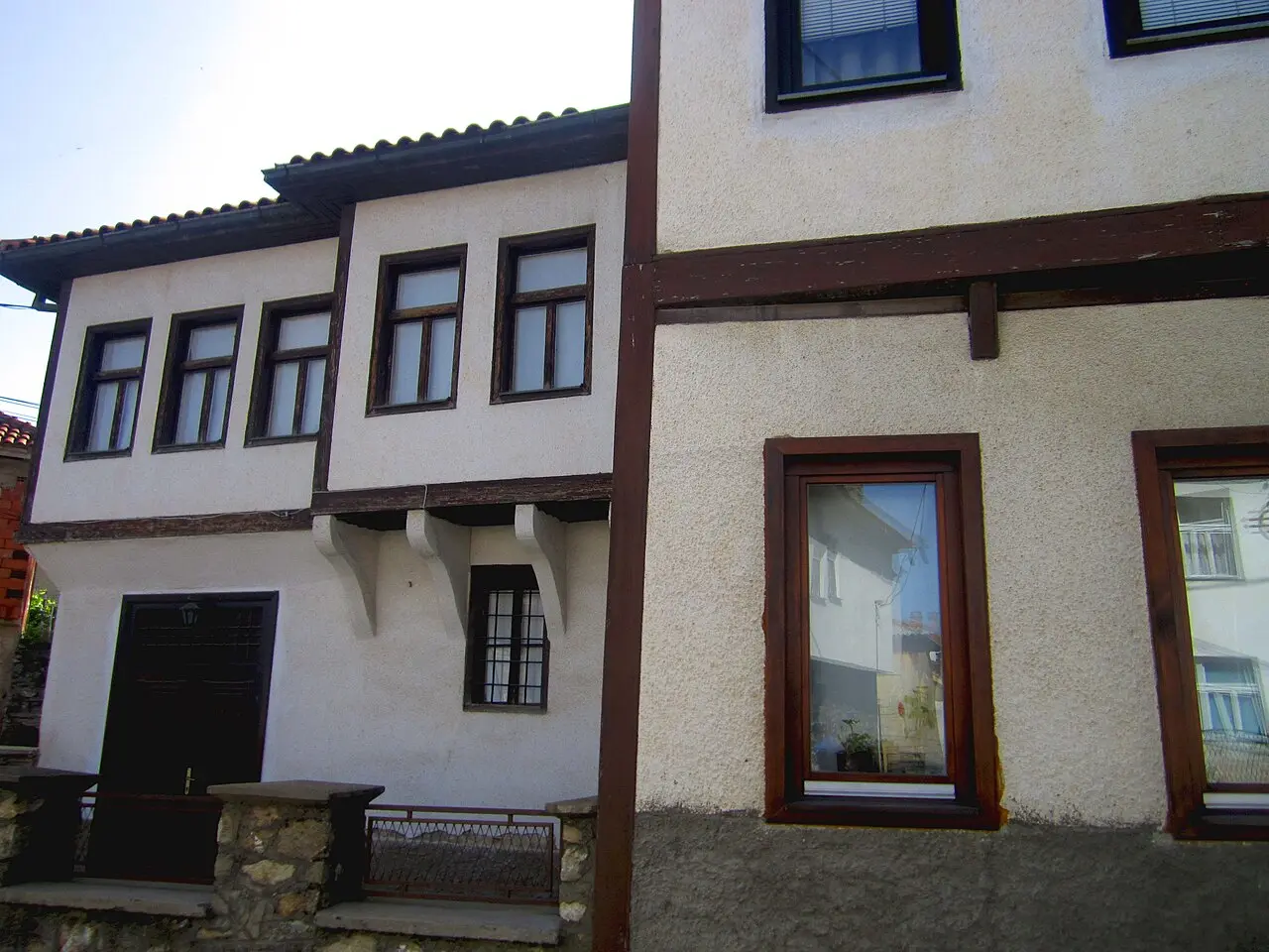 A white-plastered Kruševo town house with dark timber framing and latticed windows