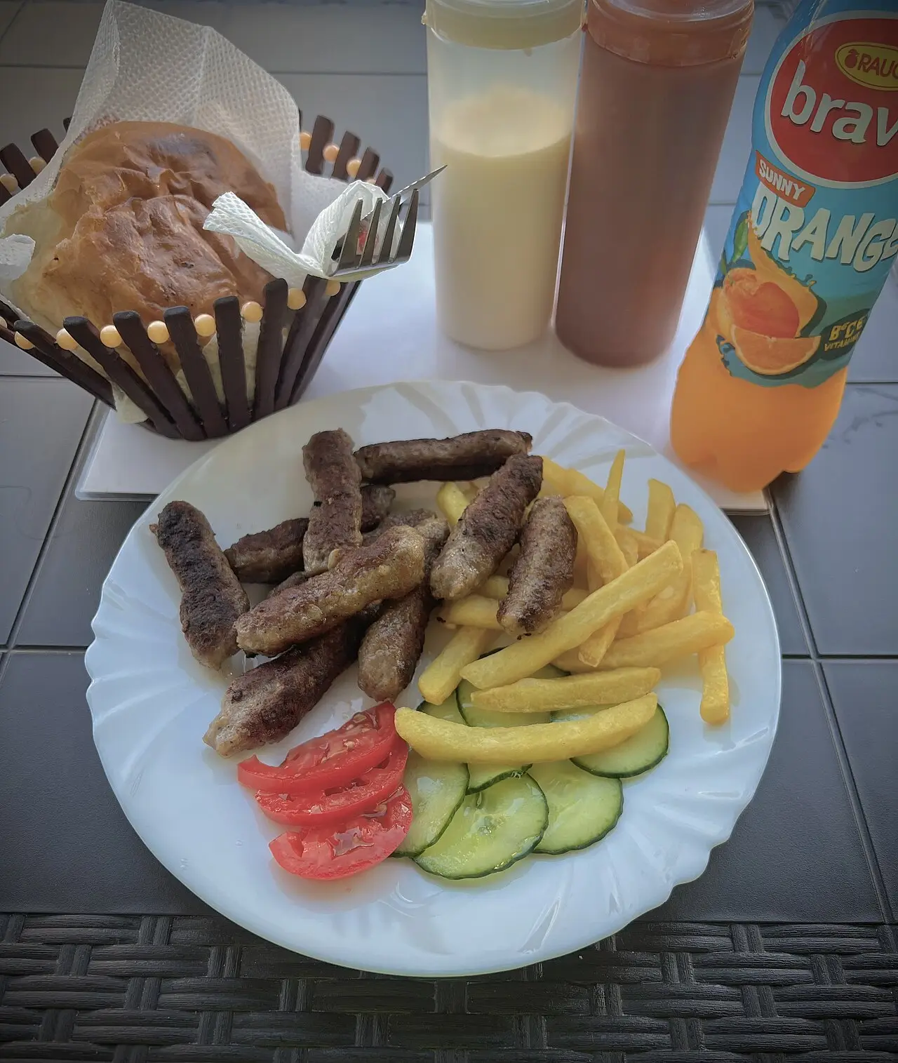 Plate of kebap with fries and salad on a restaurant table in Ohrid
