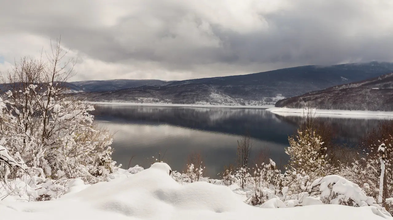 A wide view of Lake Mavrovo reservoir backed by forested mountains