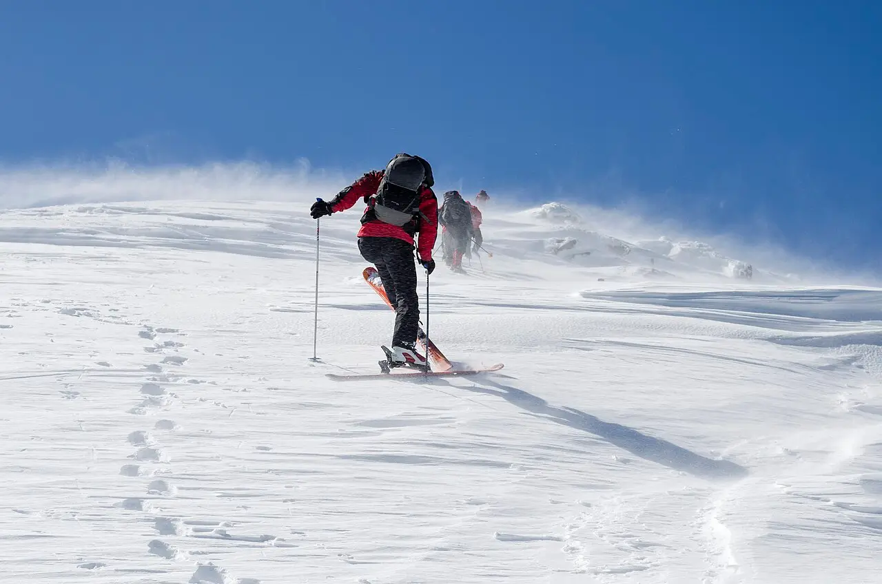 A ski tourer climbing a windswept snow slope above Mavrovo with skins on