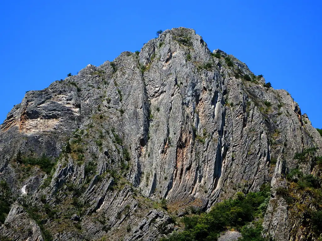 The green water of Matka Canyon between steep wooded cliffs near Skopje