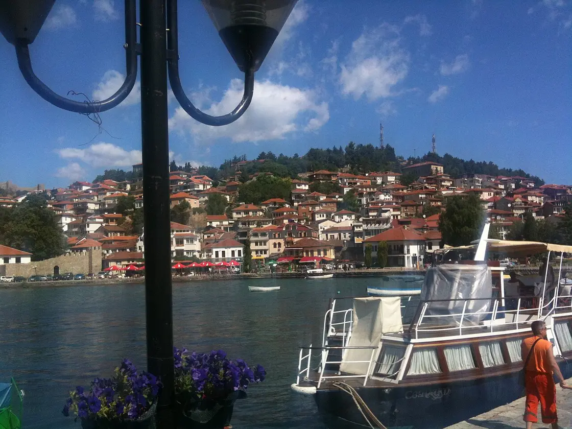 Red-roofed houses of Ohrid old town descending to the lake, seen from a tour boat at the dock