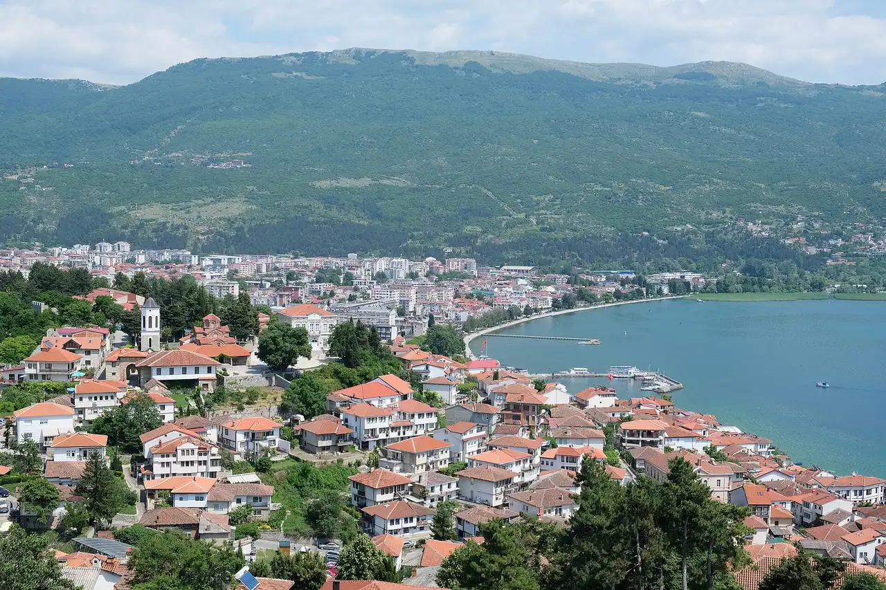Ohrid old town of red-tiled houses stepping down to the lake and harbour, seen from the fortress, with the Galicica mountains behind