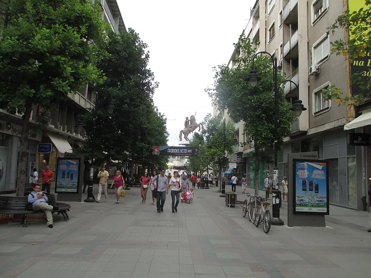 Pedestrian shopping street in central Skopje with shopfronts and people walking on a clear day