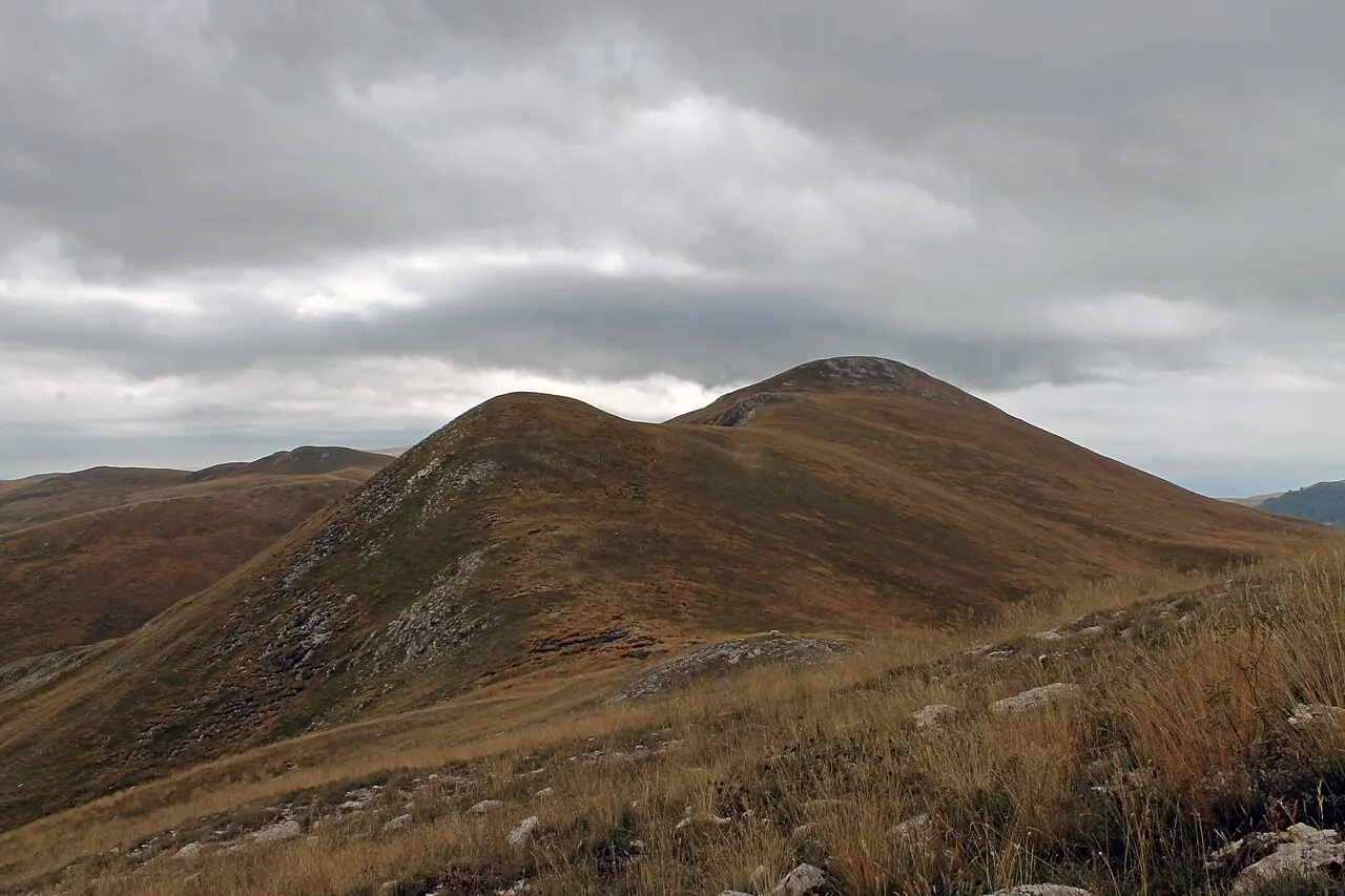 The rolling grassy summits of Bistra mountain in Mavrovo National Park under a cloudy autumn sky