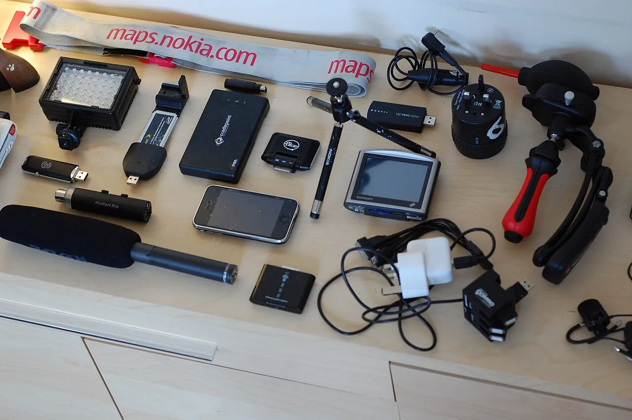 Open travel tech pouch with cables, adapters and small electronics packed for a trip