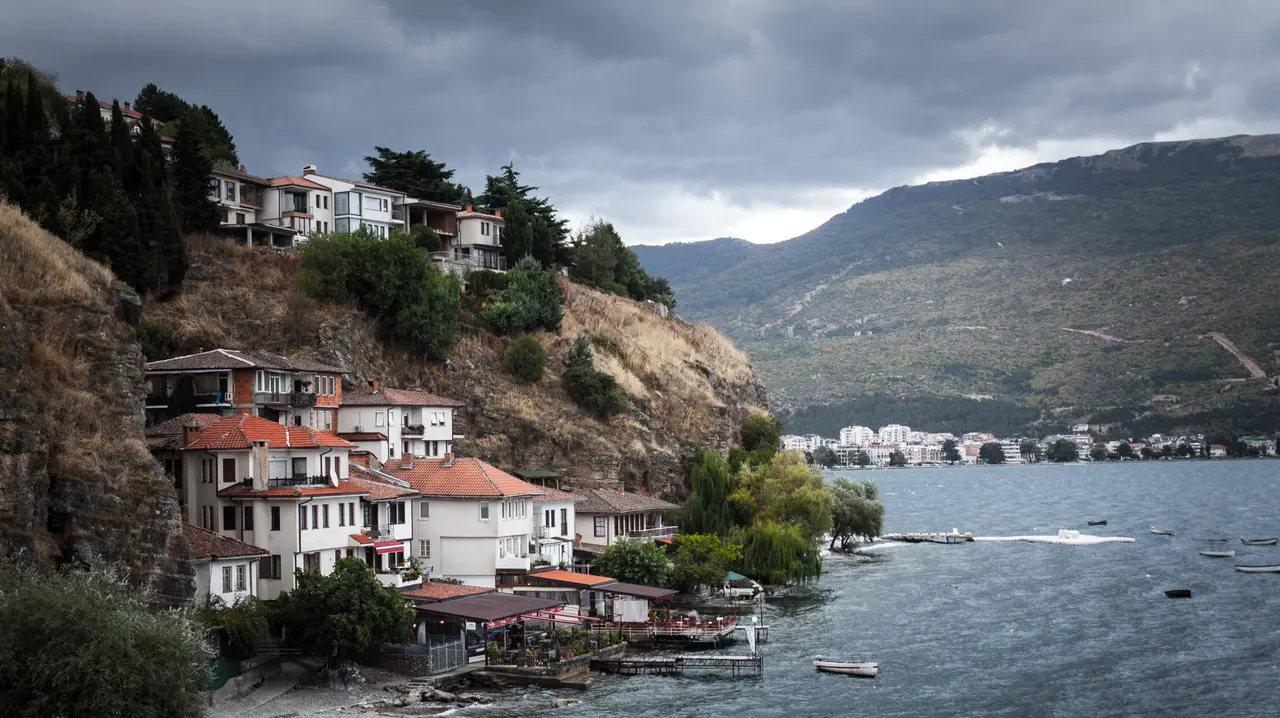 The Kaneo neighbourhood of Ohrid stepping down stone-and-tile houses to the lake, with mountains beyond