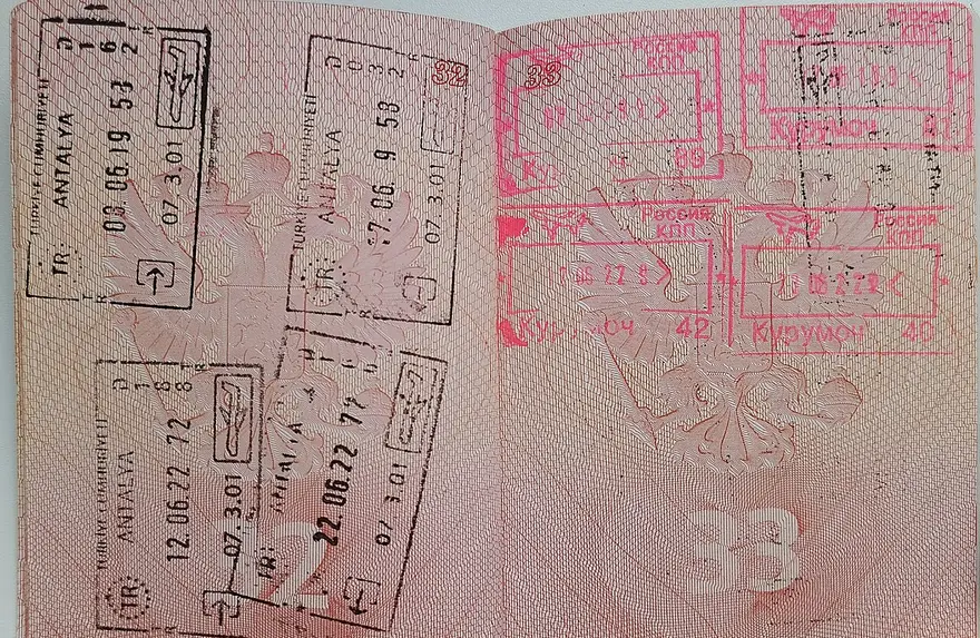 An open passport filled with entry and exit stamps
