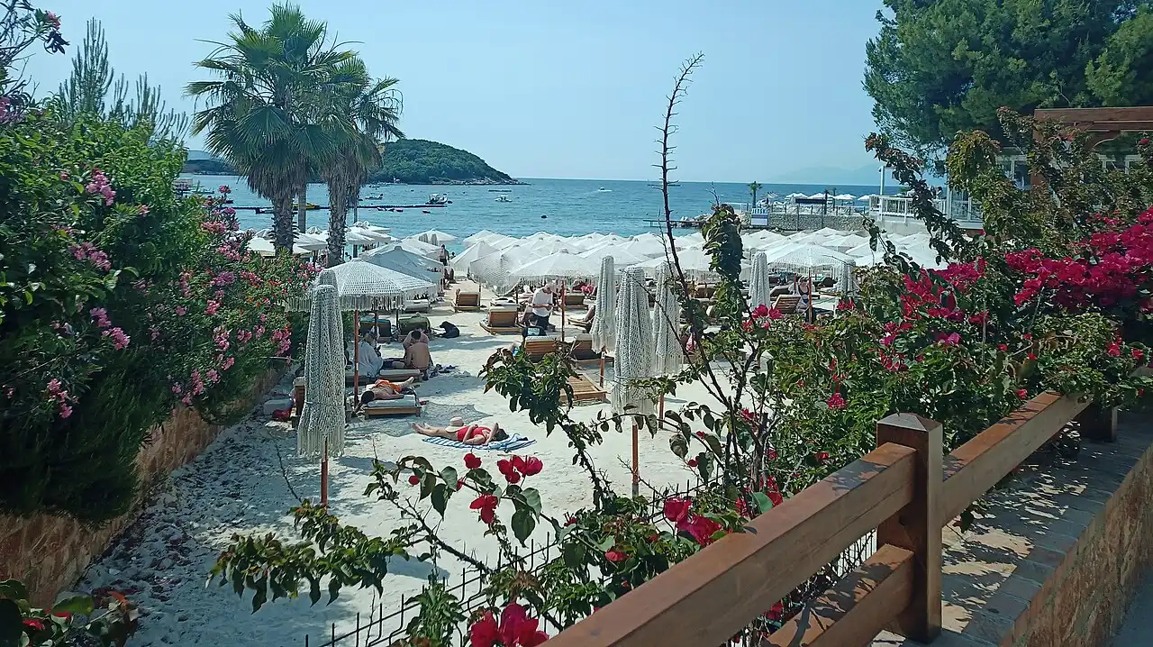 The white-sand beach and turquoise water of Ksamil on the Albanian Riviera, with small islands offshore