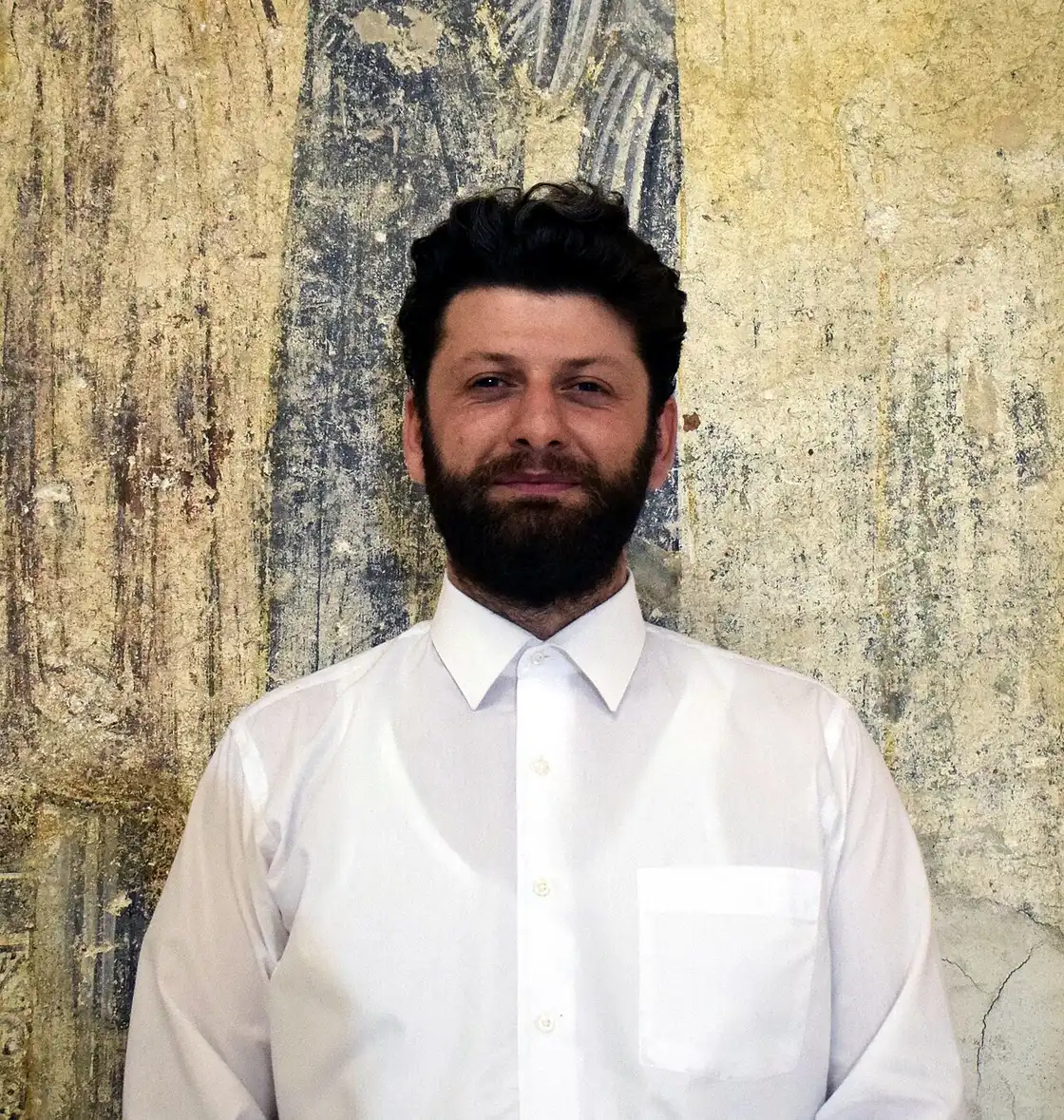 A festival musician stands in front of the faded medieval frescoes inside St Sophia Church in Ohrid