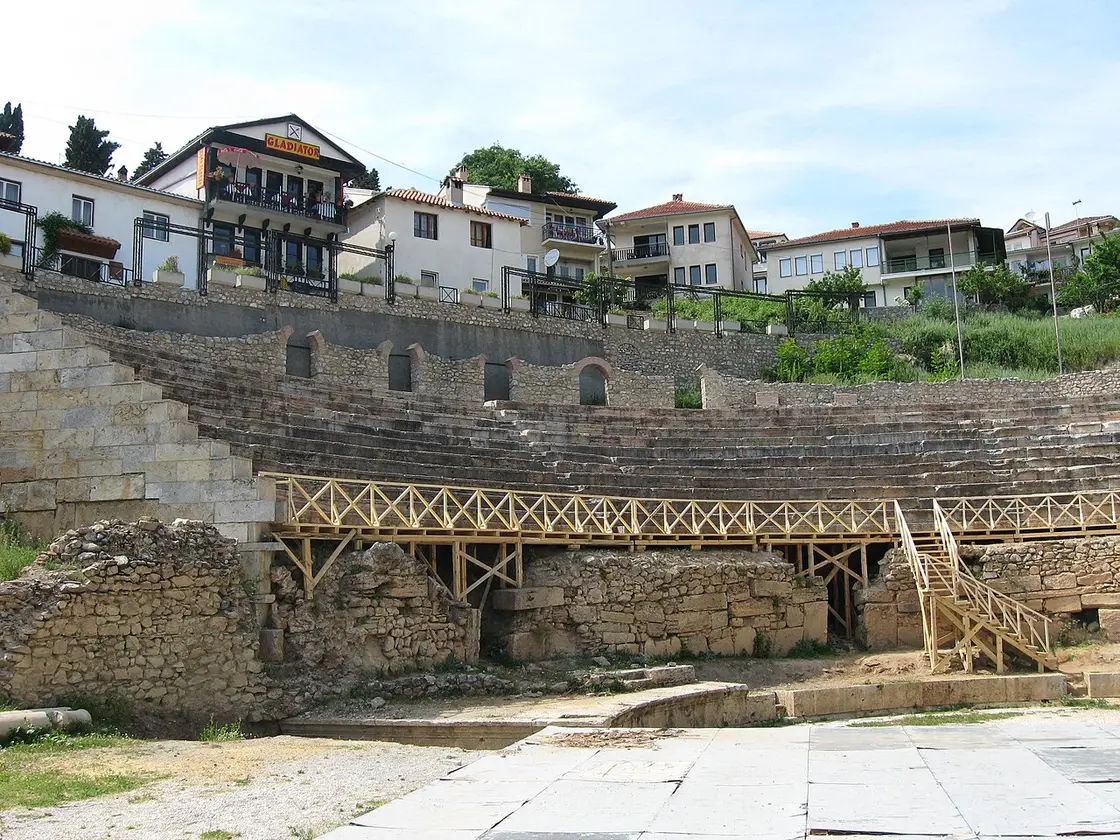 The restored stone tiers of the ancient theatre in Ohrid, with the old town's houses rising behind