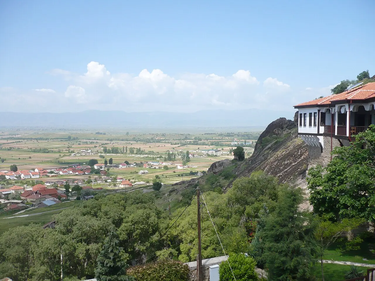 Treskavec monastery buildings perched on a cliff edge above the wide Pelagonia plain near Prilep