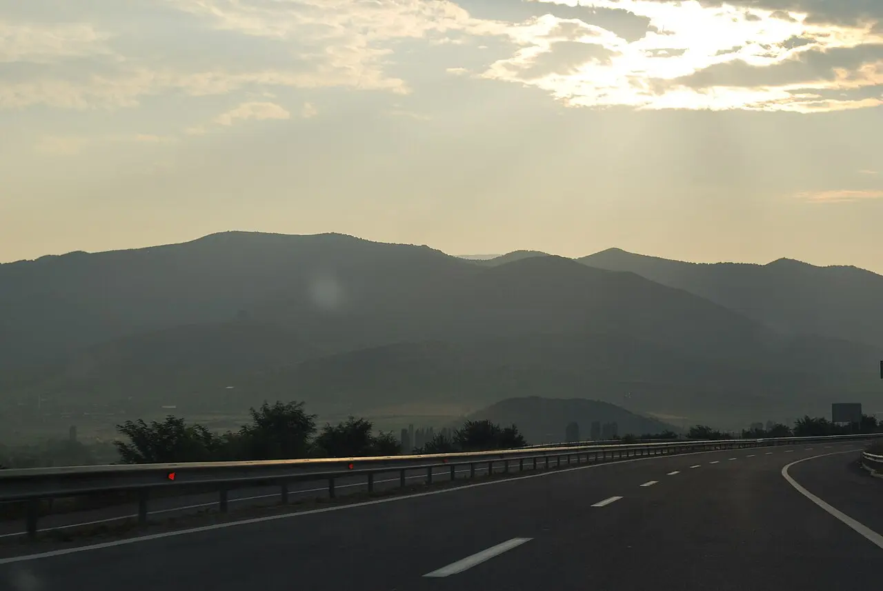 An empty North Macedonian motorway at dusk with hills on the horizon