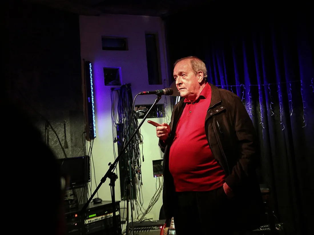 Oliver Belopeta, founder and director of Skopje Jazz Festival, speaking into a microphone at a small venue