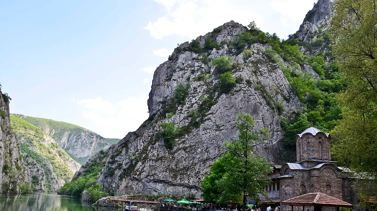 The green water of Matka Canyon with the medieval church of Sveti Andrea below the cliffs near Skopje