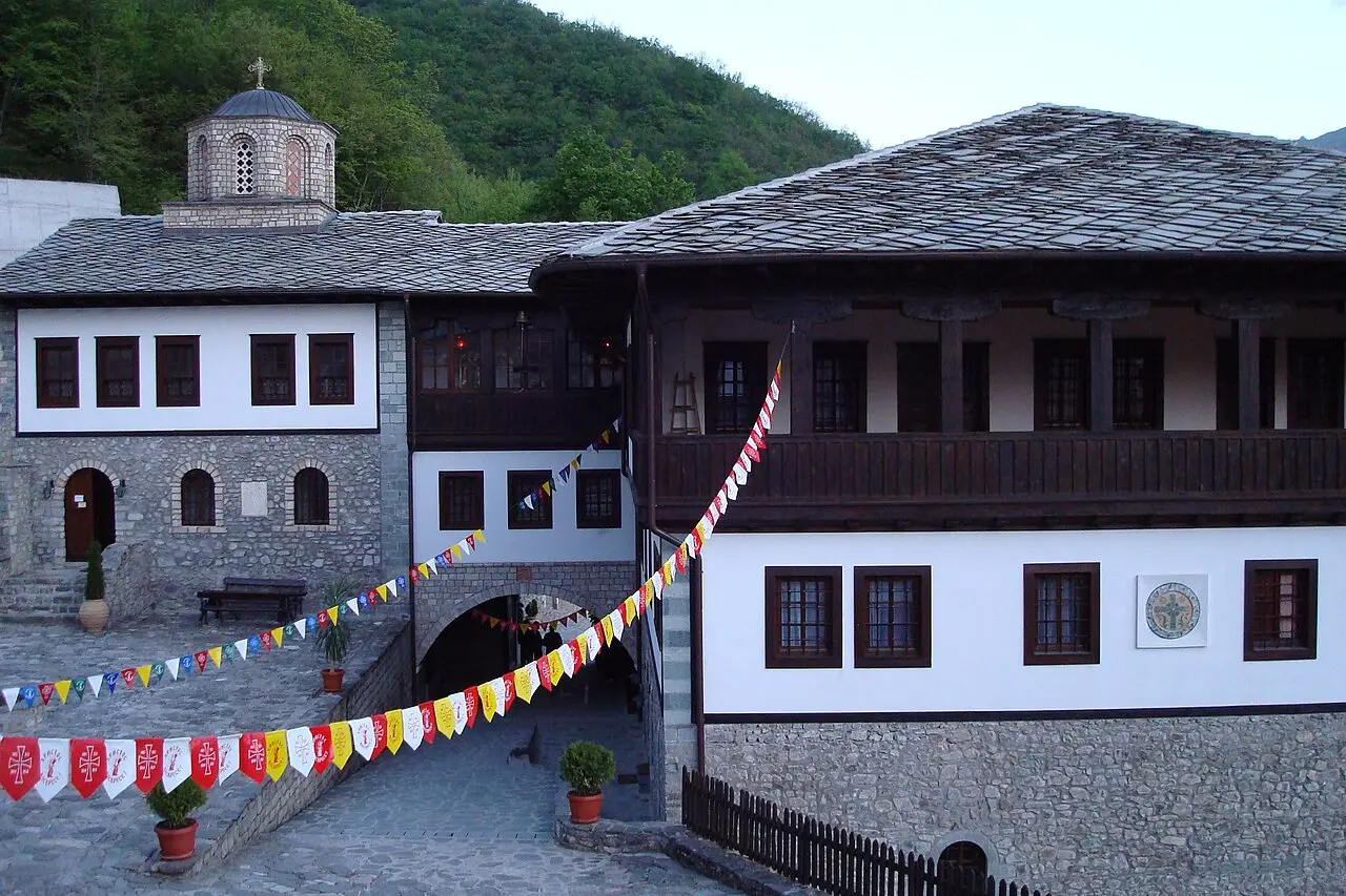 The stone-and-timber courtyard of Bigorski Monastery with its carved wooden balcony and domed church