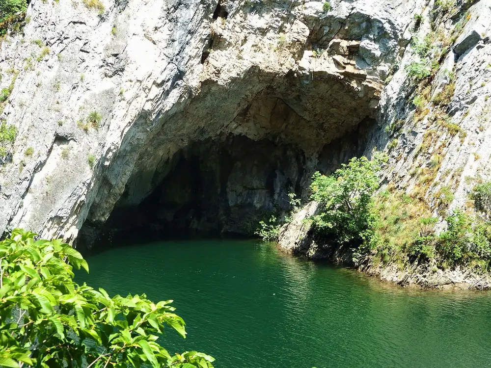 The mouth of the Vrelo cave over the emerald water of Matka Canyon, reached by boat