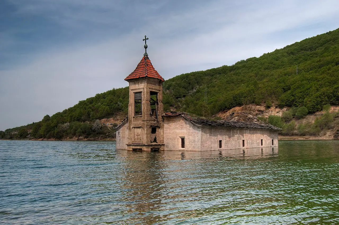 The half-submerged stone Church of St. Nicholas standing in the water of Lake Mavrovo