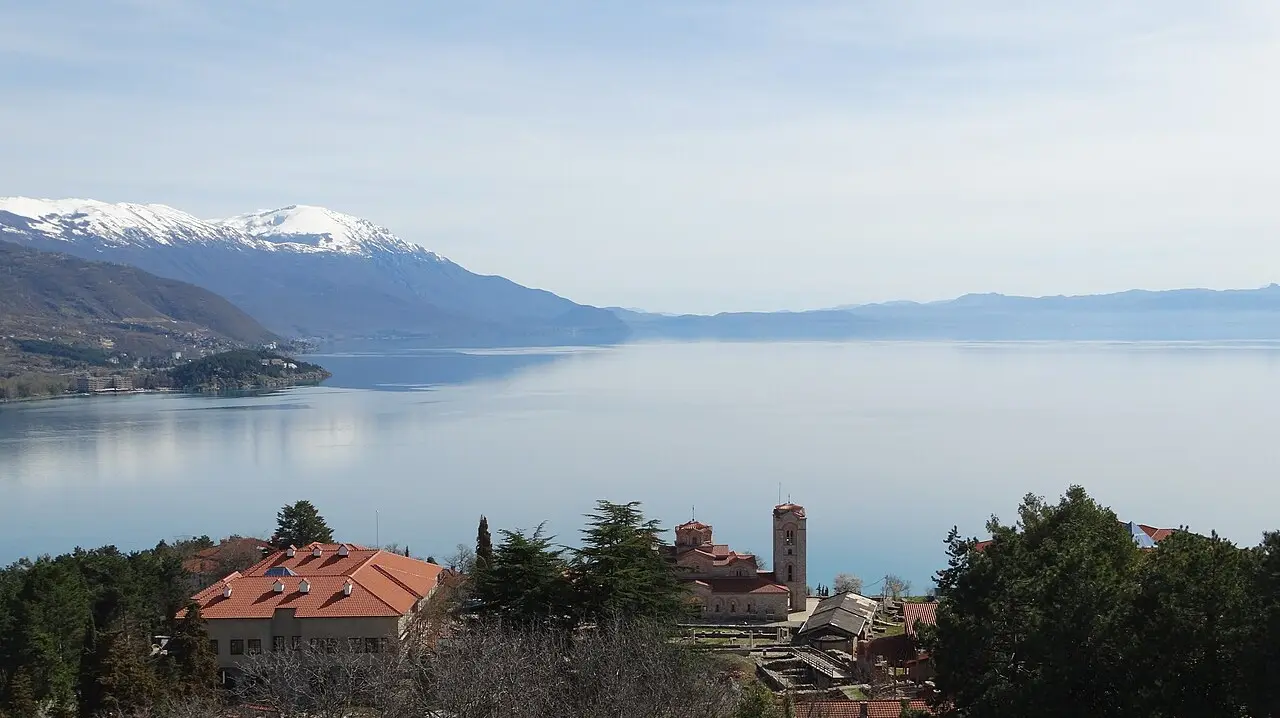 Lake Ohrid seen from above with the Plaosnik church complex and snow-capped Galicica mountains beyond