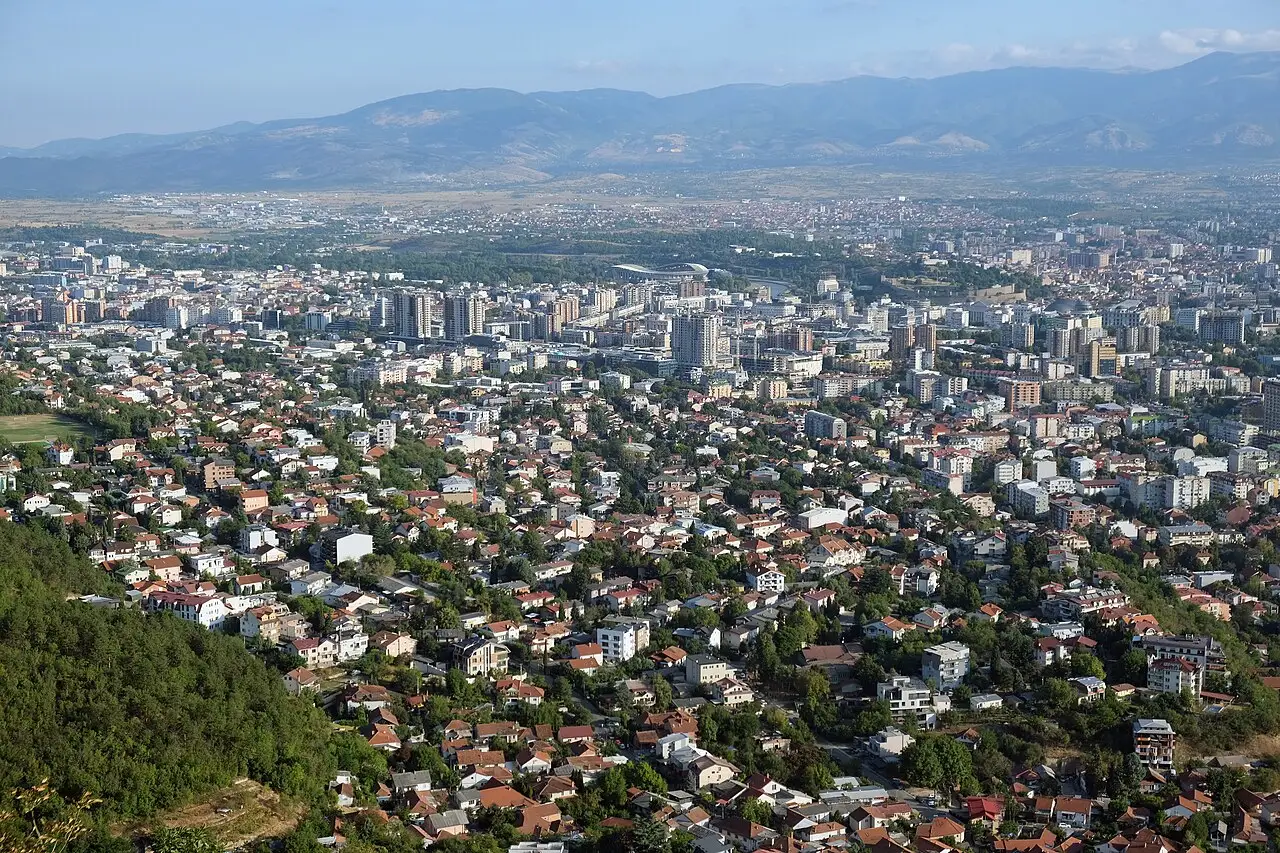 A wide valley view over Skopje from Vodno mountain, with distant hills behind the city