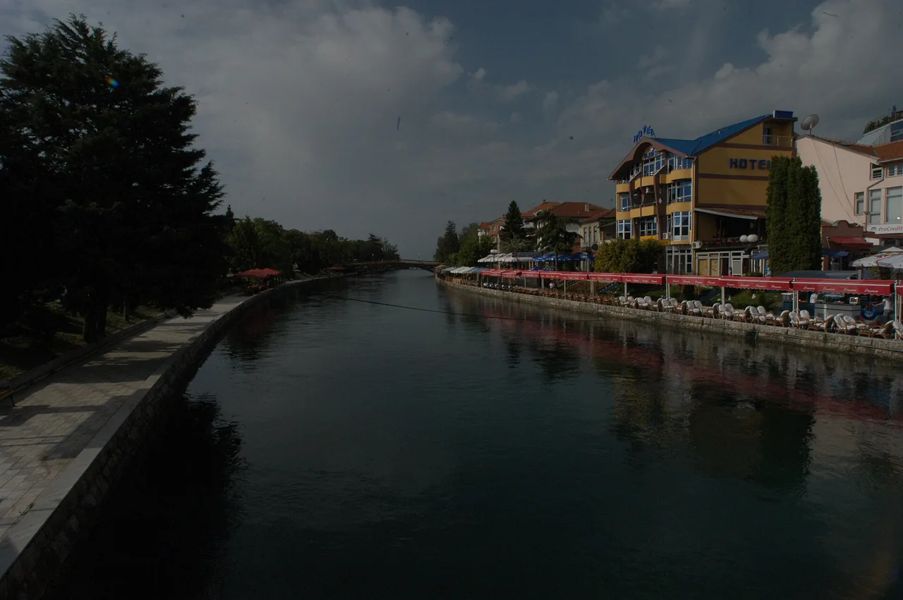Looking along the Black Drin through Struga with multiple bridges and riverside trees