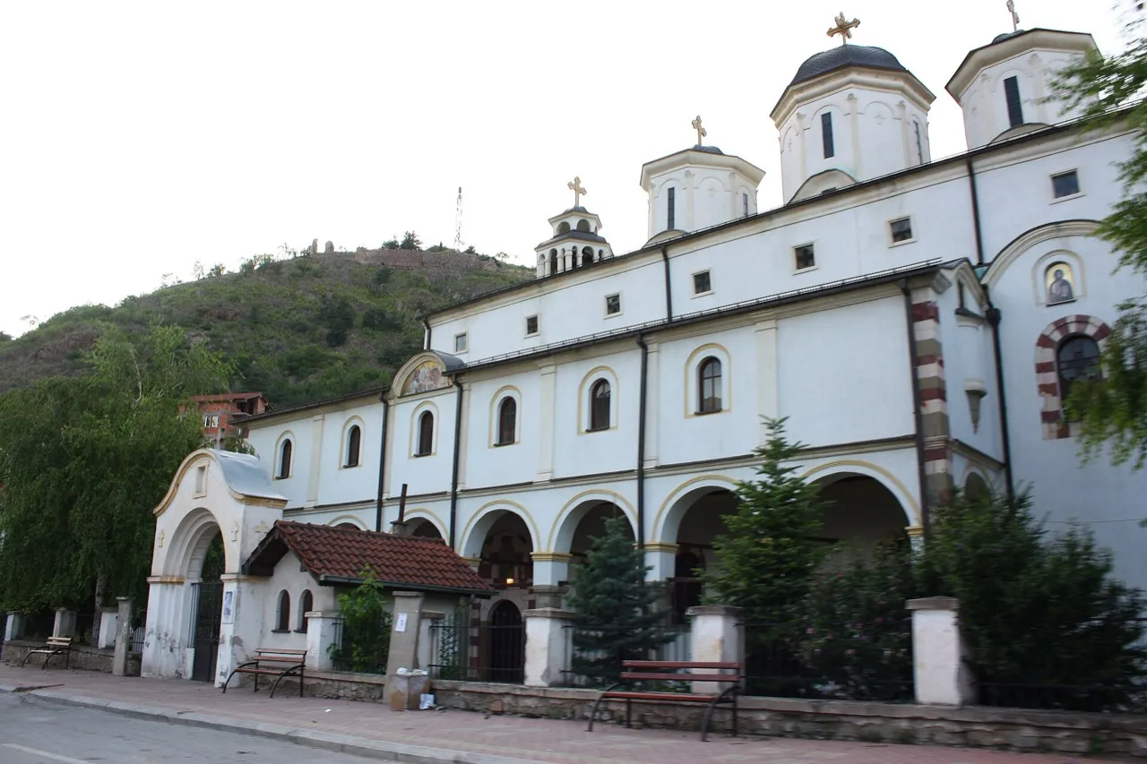 The whitewashed domed exterior of St Nicholas Cathedral in Stip, with a wooded hill rising behind it