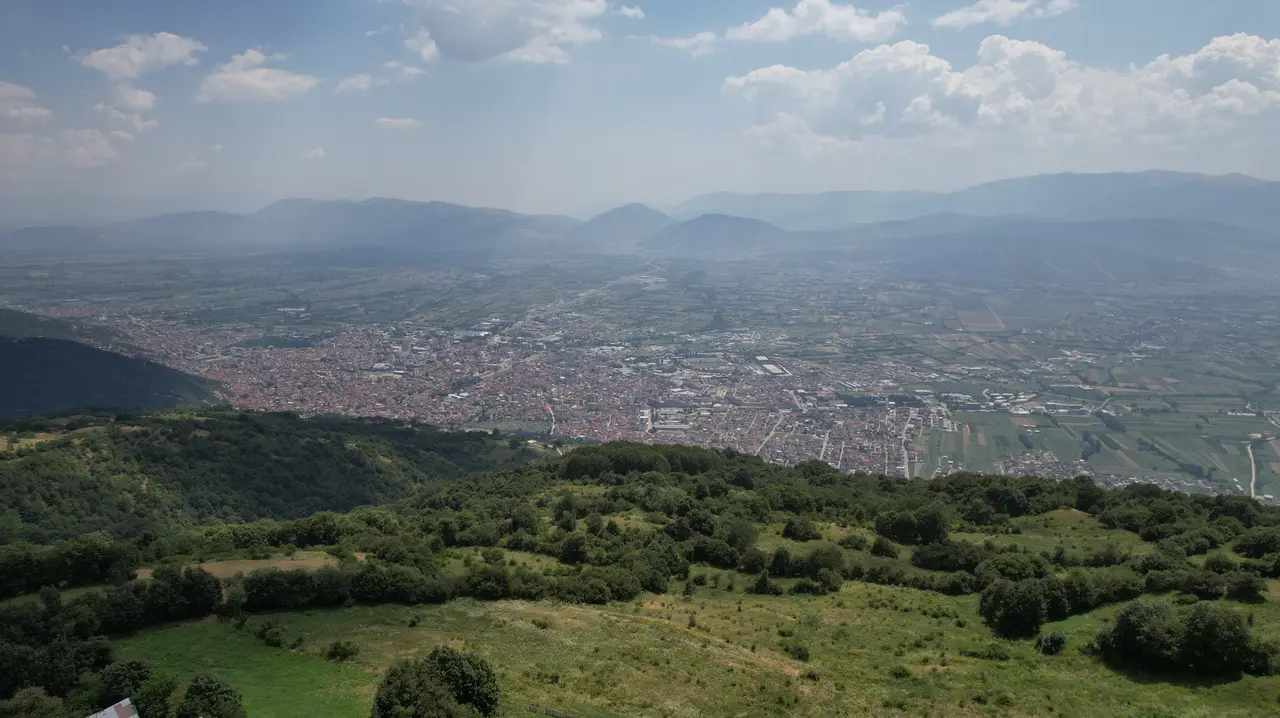 Aerial view over the city of Tetovo spread across the Polog plain with the Šar mountains hazy behind