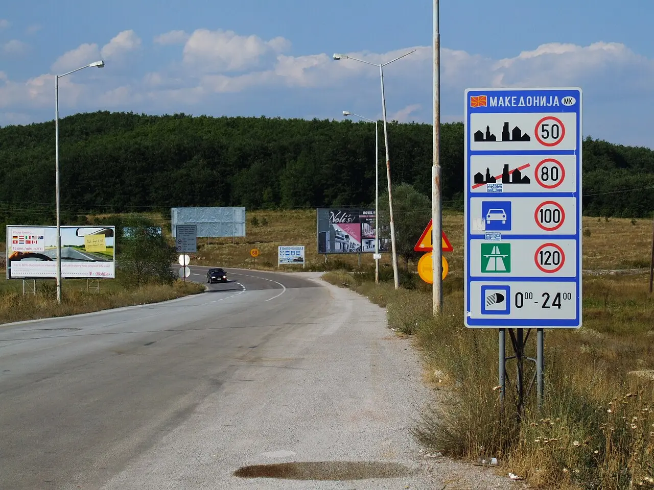 A road approaching the North Macedonia border with a sign reading Македонија and speed limits
