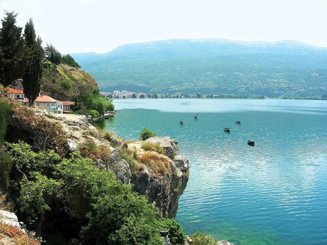 The lakeside town of Ohrid seen from the Kaneo headland, houses and terraces lining the shore of the clear lake