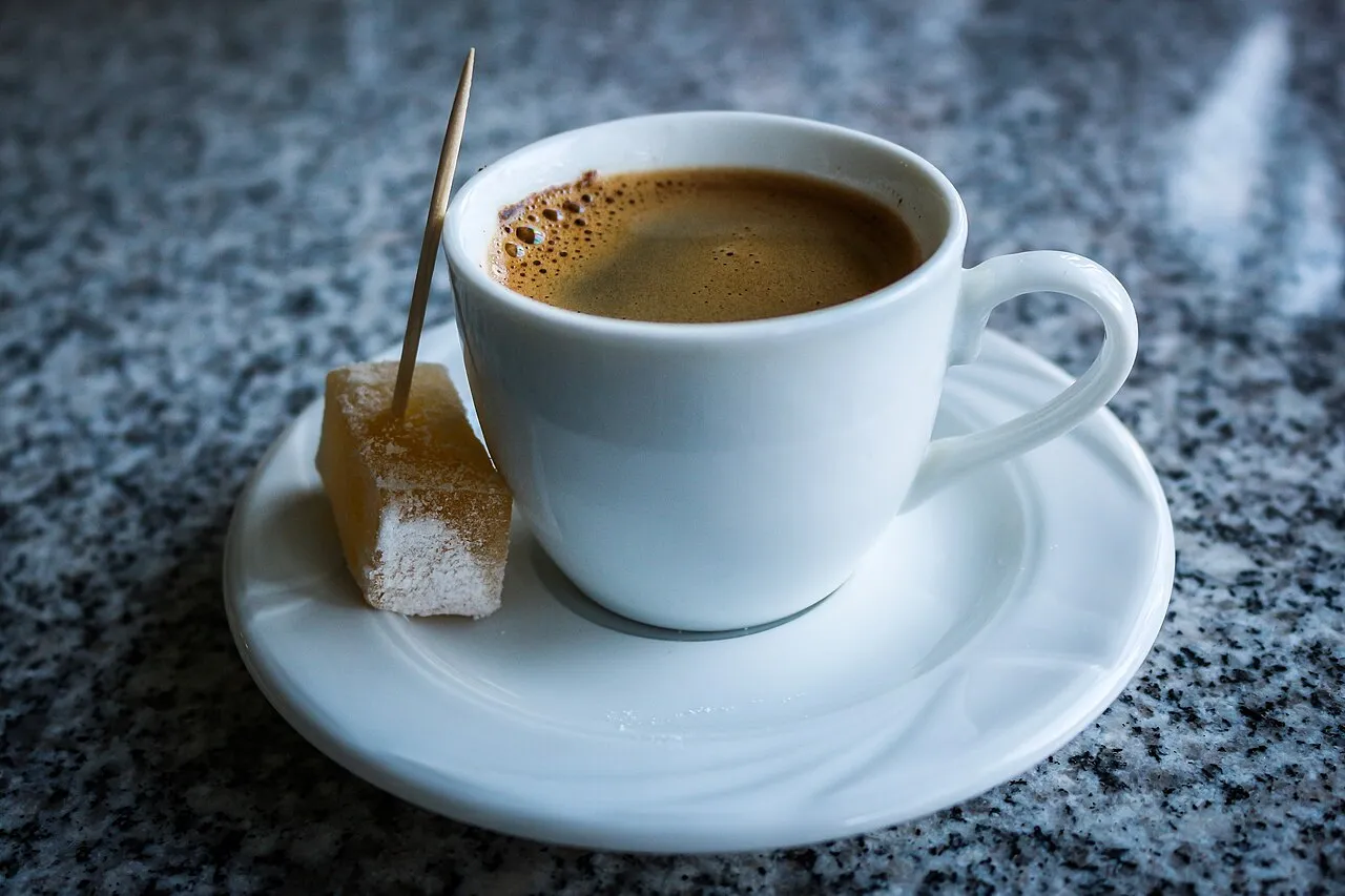 A cup of Macedonian Turkish coffee with a piece of lokum on the saucer