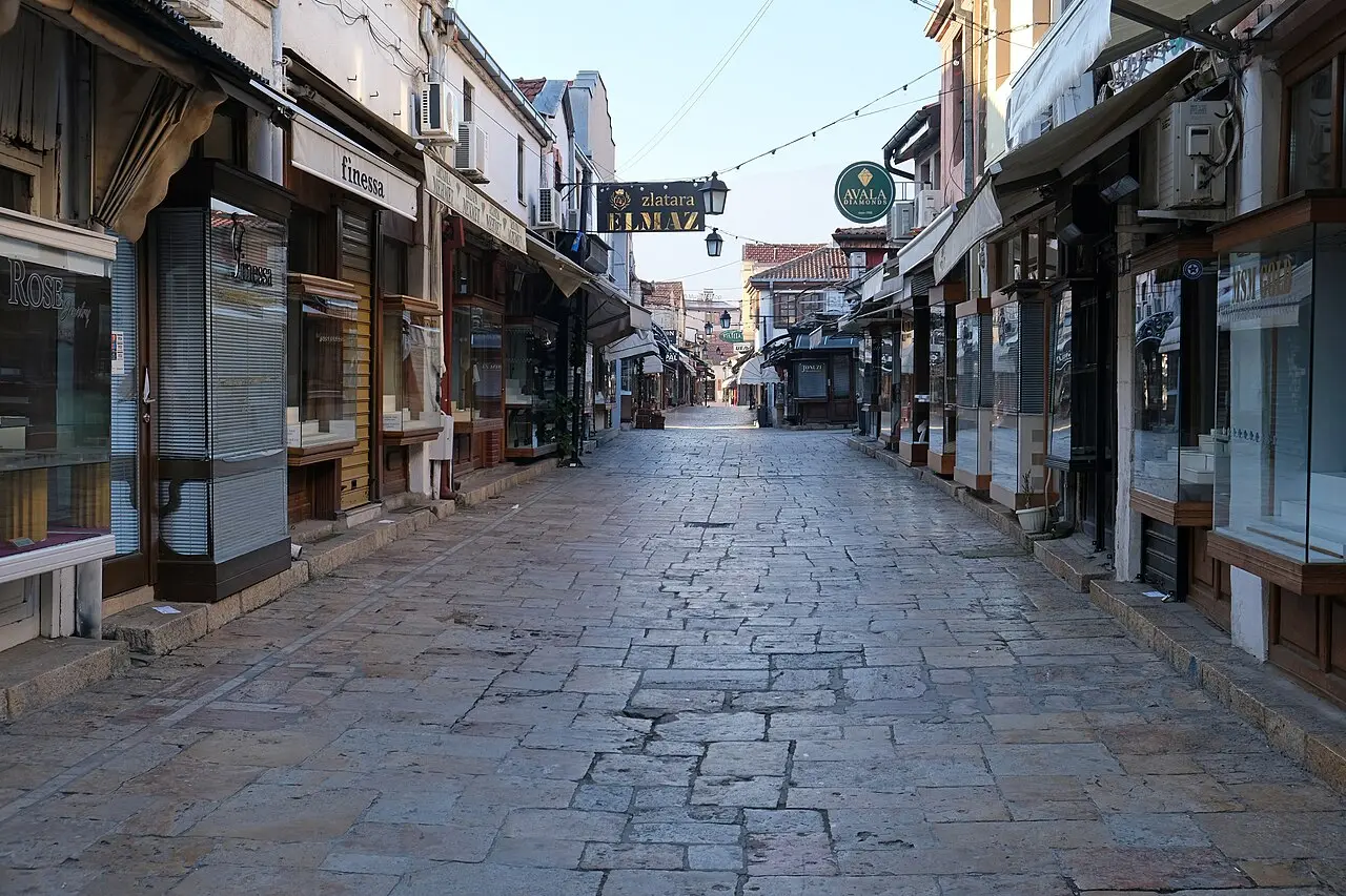A cobbled lane in Skopje Old Bazaar lined with shuttered shops and awnings in the early morning