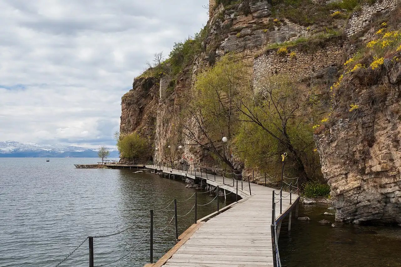 The wooden Ohrid boardwalk pinned to the cliffs and curving over the water of Lake Ohrid below the old fortress walls