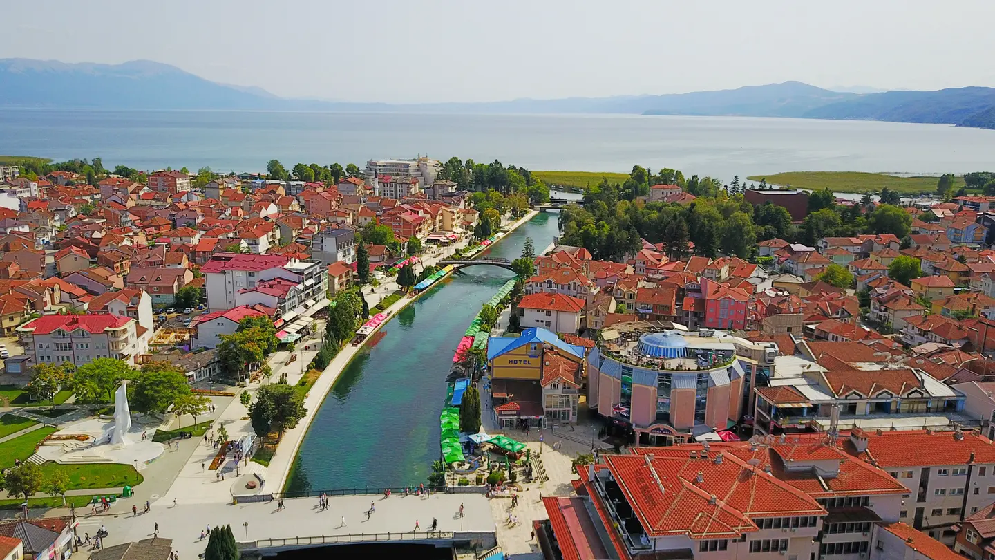 Aerial view of Struga with the green Black Drin river running between the town and out into Lake Ohrid